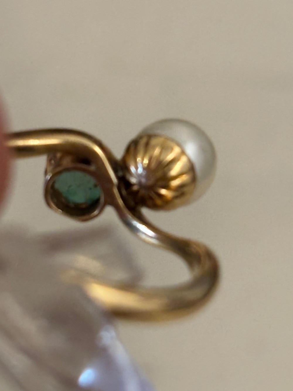 A yellow gold bypass ring featuring a round white cultured pearl alongside a claw-set green jade cabochon. View V