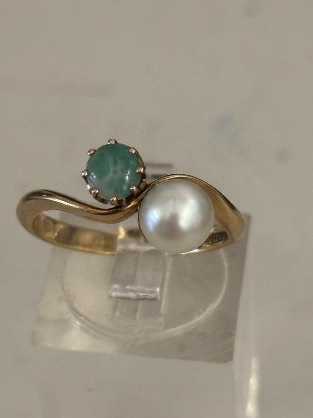 A yellow gold bypass ring featuring a round white cultured pearl alongside a claw-set green jade cabochon. View VI