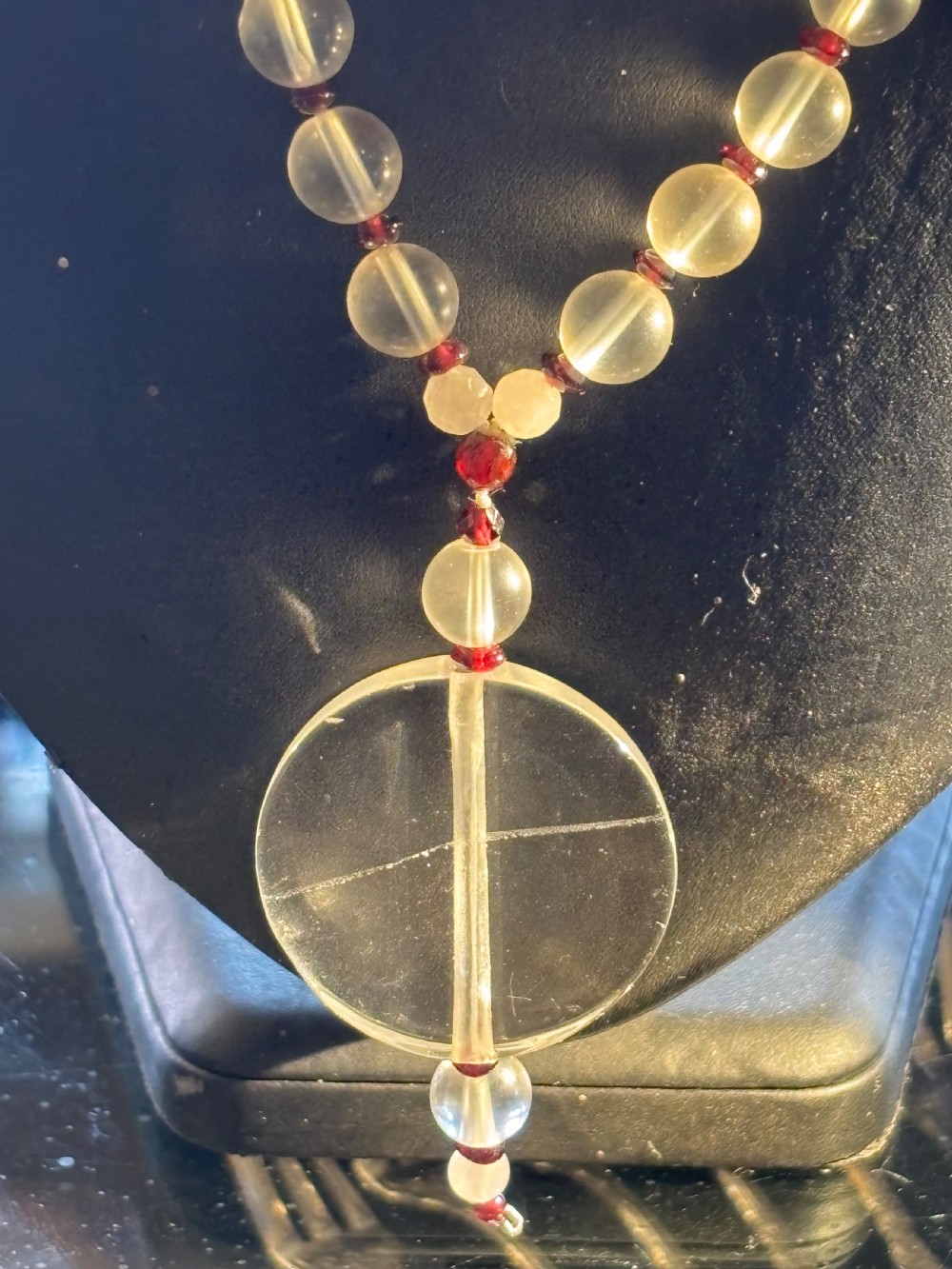 An Art Deco necklace composed of clear spherical rock crystal beads ending with a large round crystal disc pendant. View VII