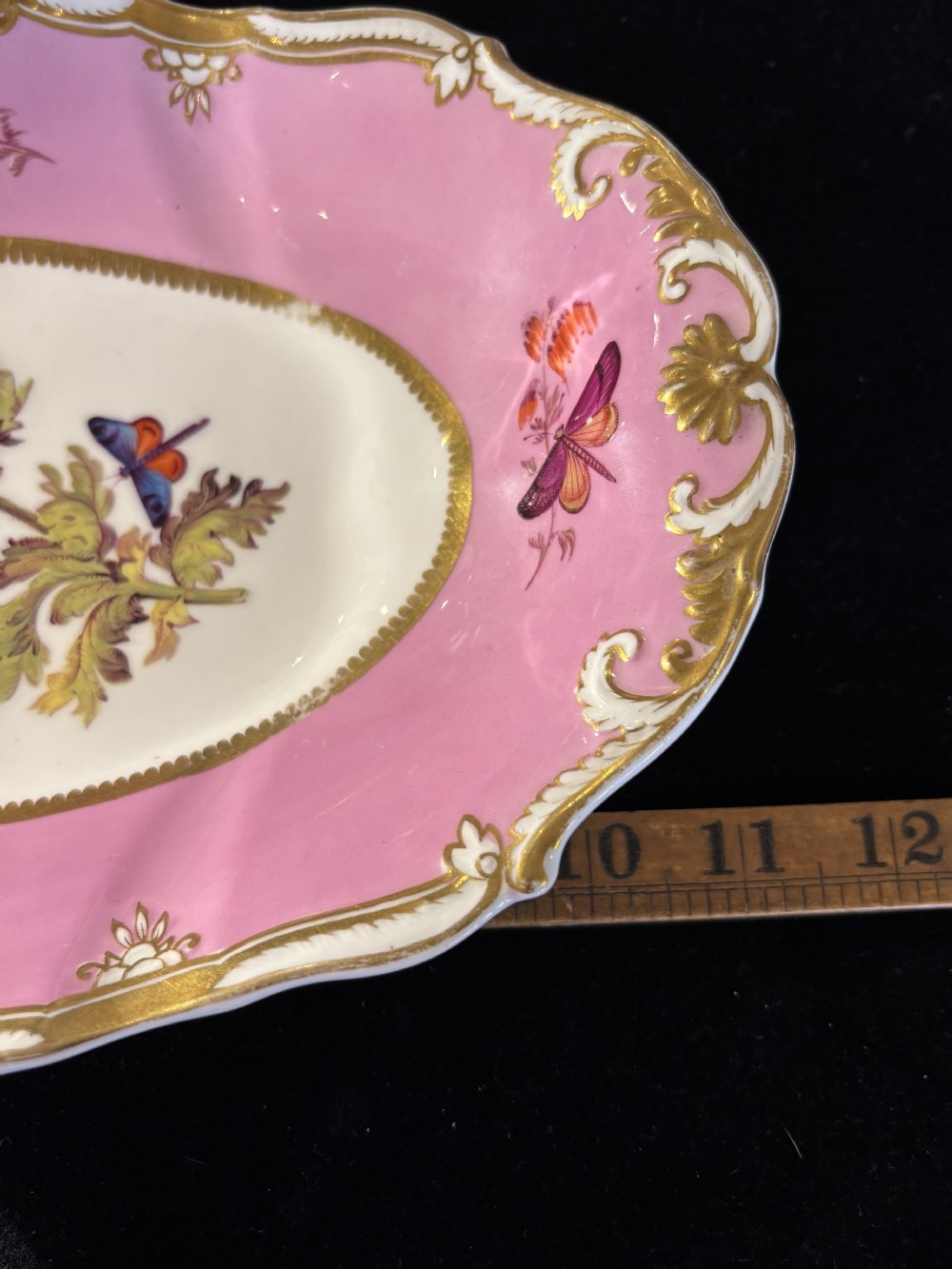 A pair of oval Georgian Spode porcelain dishes featuring scalloped pink and gold borders surrounding central hand-painted floral and butterfly motifs. View XII