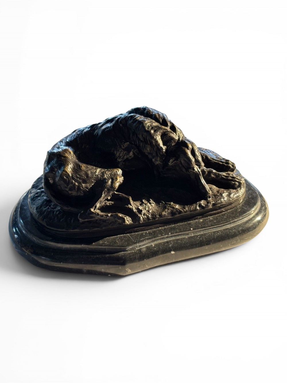 A dark patinated bronze sculpture of a reclining sighthound resting on a moulded dark marble plinth.