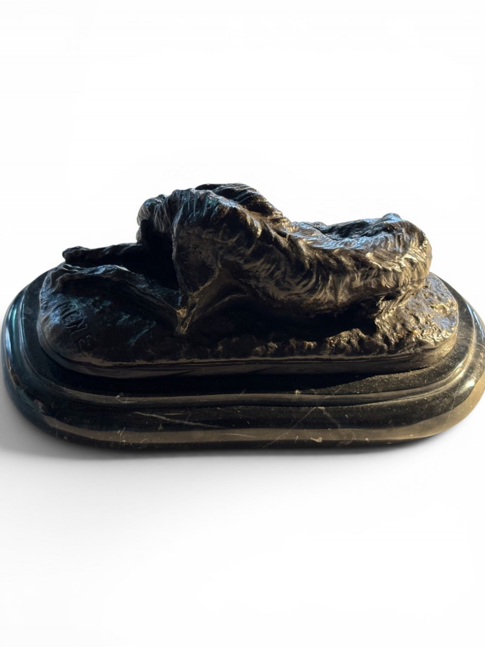 A dark patinated bronze sculpture of a reclining sighthound resting on a moulded dark marble plinth. View VI