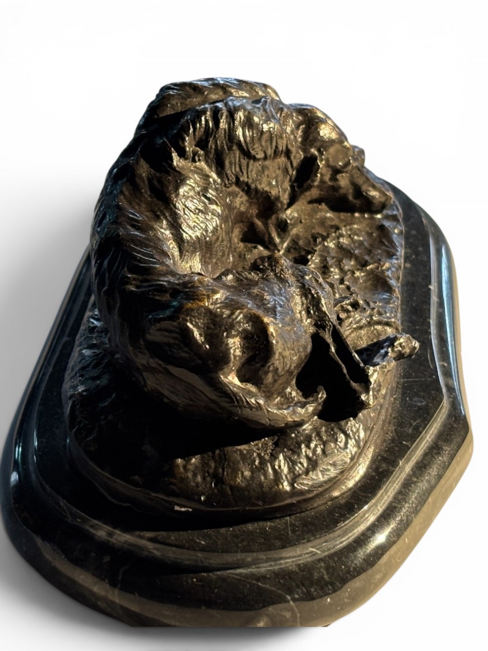 A dark patinated bronze sculpture of a reclining sighthound resting on a moulded dark marble plinth. View VII