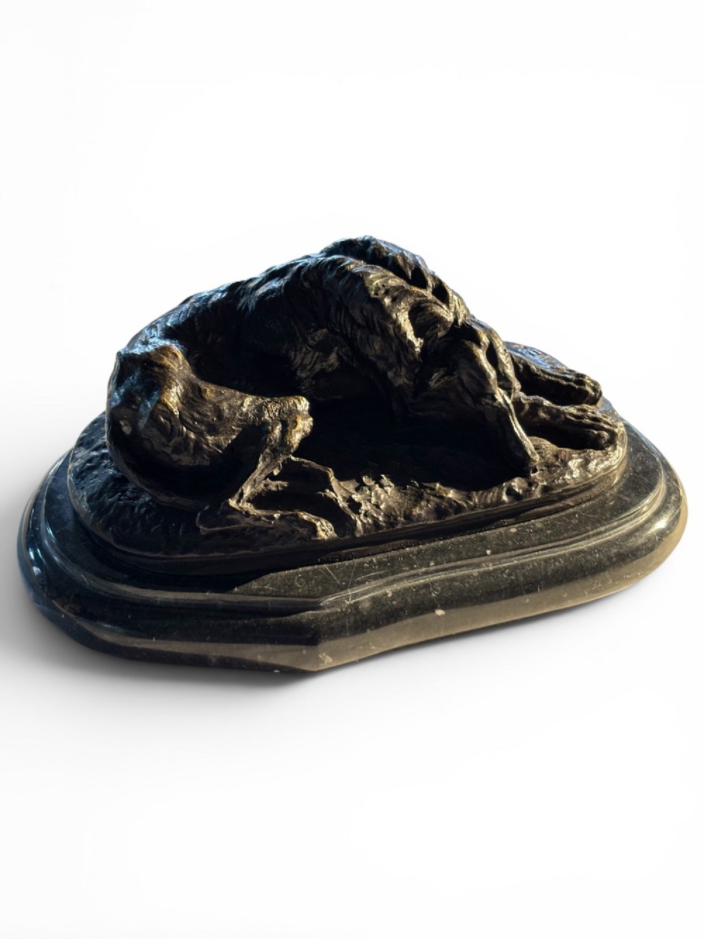 A dark patinated bronze sculpture of a reclining sighthound resting on a moulded dark marble plinth. View XII