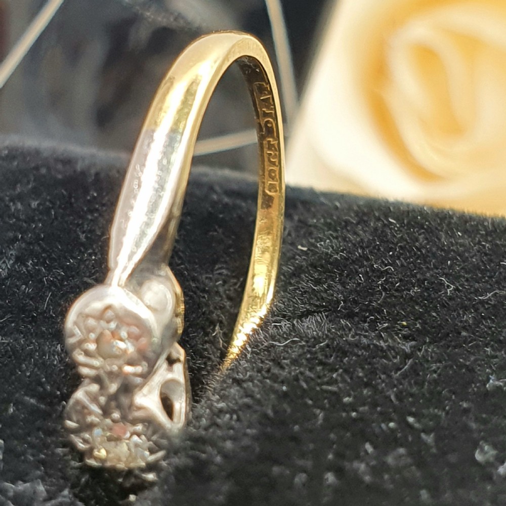 An Art Deco trilogy ring featuring three star-set round diamonds in a platinum setting on an 18ct yellow gold band. View IV