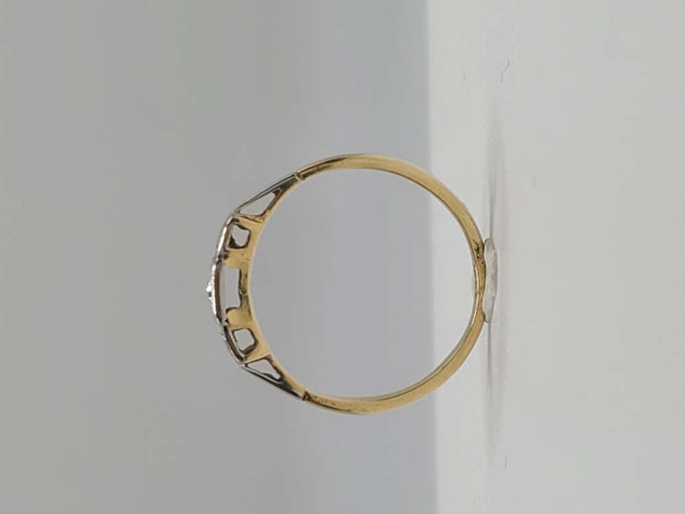 An Art Deco trilogy ring featuring three round diamonds set in star-shaped illusion palladium settings atop a yellow gold band. View VII