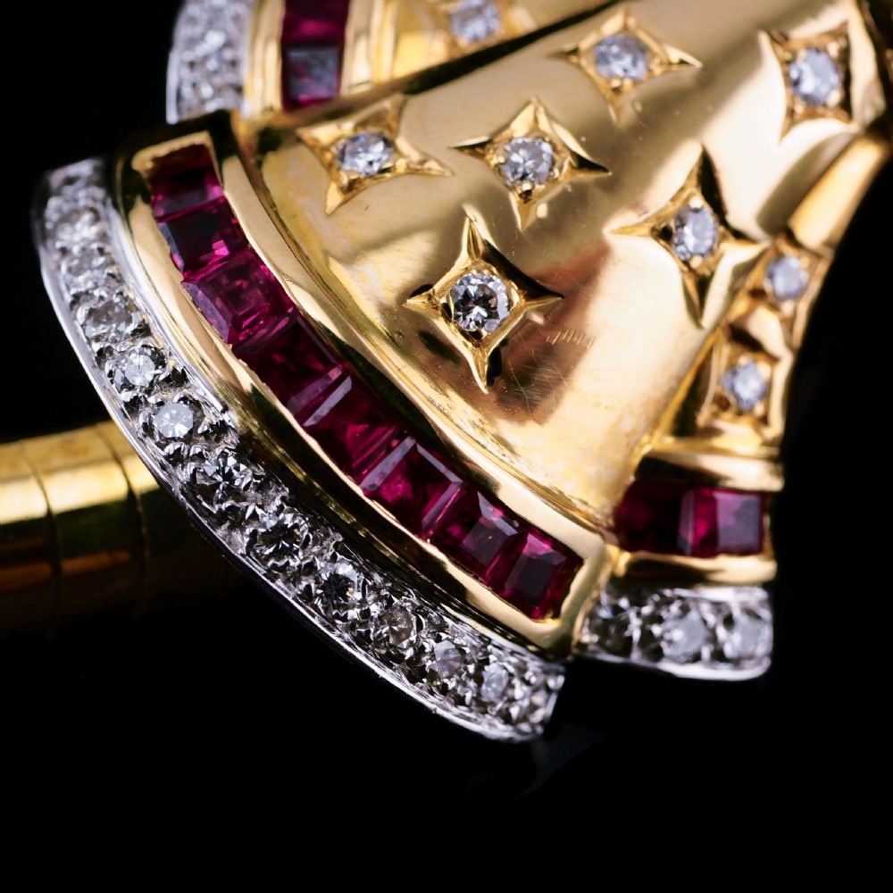 A structured 18k yellow gold collar necklace featuring a central bow motif accented with rubies and star-set diamonds above a teardrop pearl. View XVIII