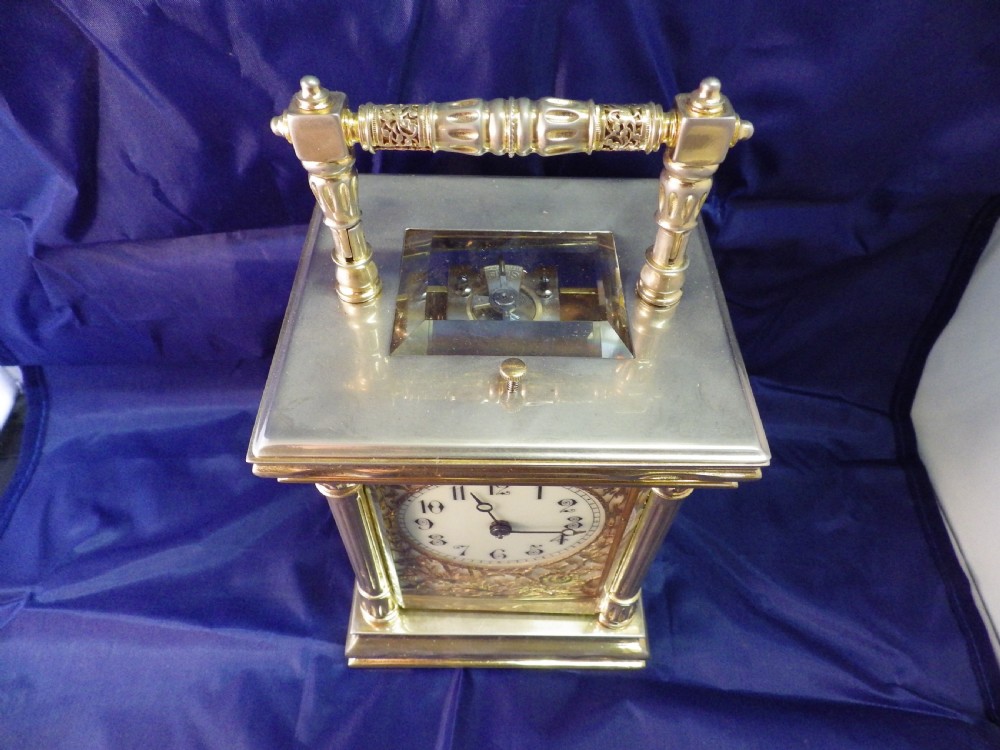 A nineteenth-century French gilt brass repeating carriage clock featuring fluted column corners, bevelled glass panels, and an ornate gilt foliate mask surrounding a central white enamel dial. View III
