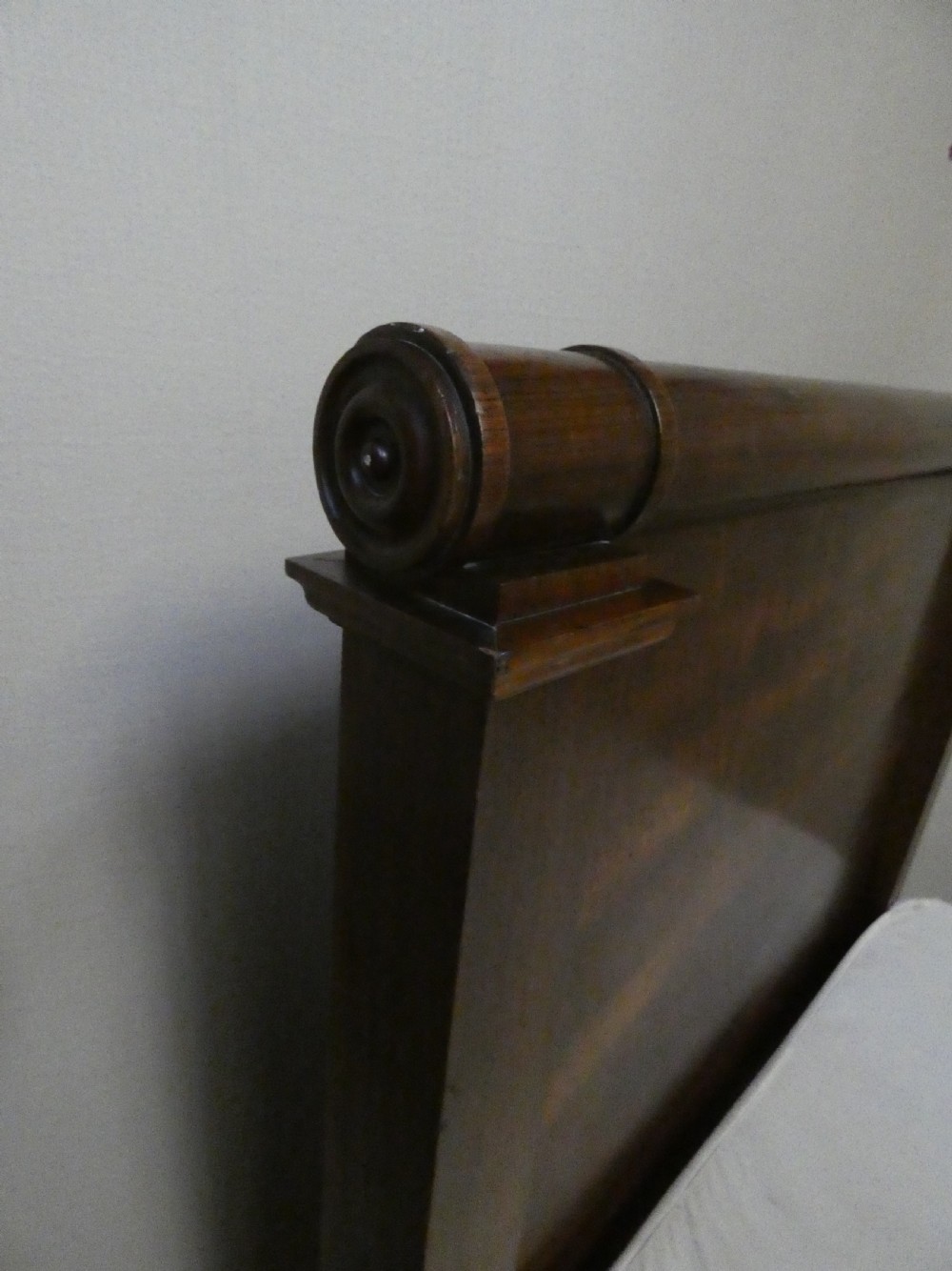 An antique dark mahogany single bed frame featuring a rolled scroll cresting rail on the headboard and footboard. View VII