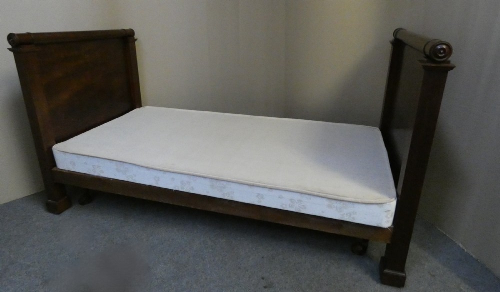 An antique dark mahogany single bed frame featuring a rolled scroll cresting rail on the headboard and footboard. View VIII