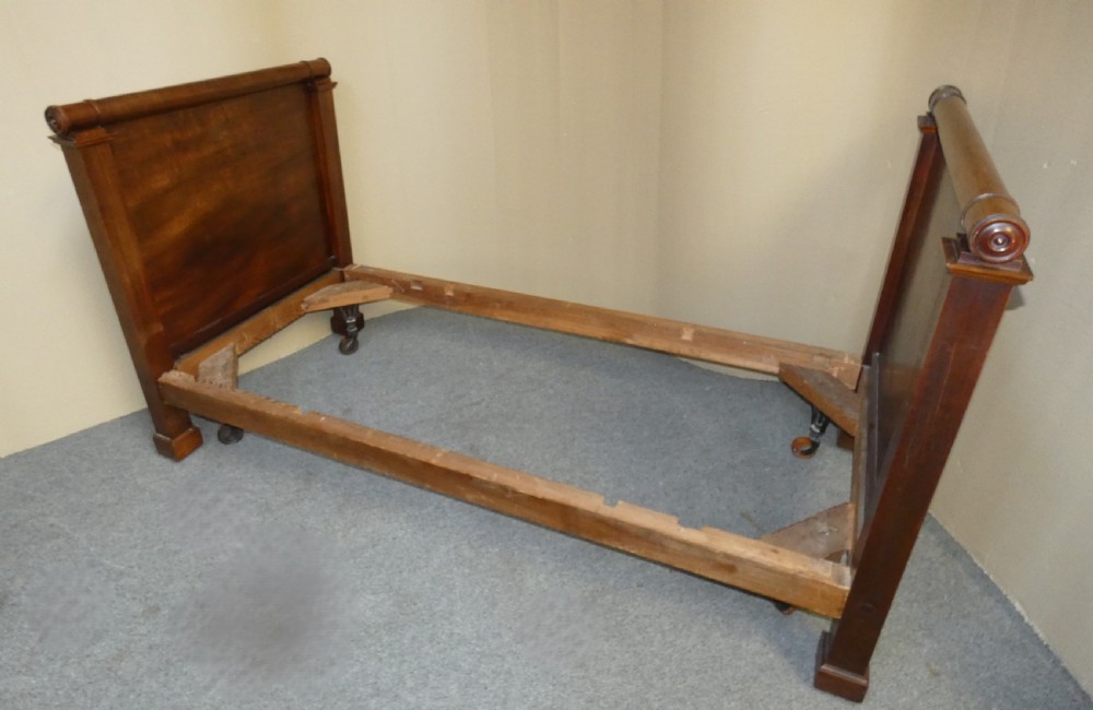An antique dark mahogany single bed frame featuring a rolled scroll cresting rail on the headboard and footboard. View XII