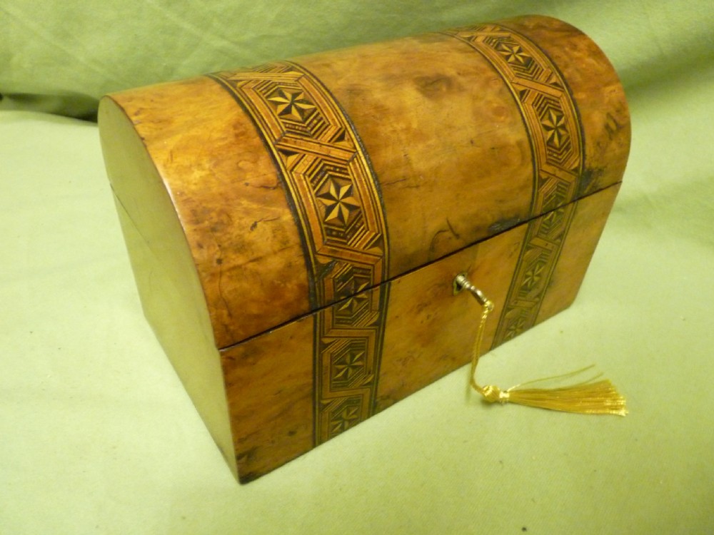 An open Victorian burr walnut tea caddy showcasing two interior lidded compartments and exterior geometric marquetry inlay. View II