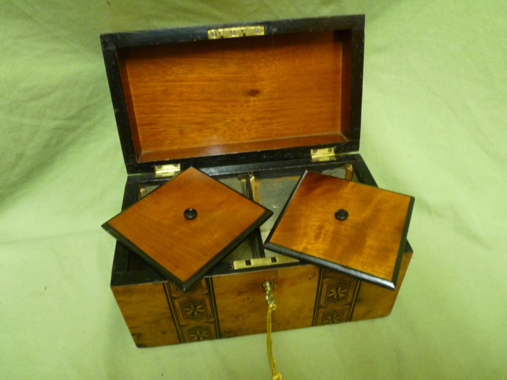 An open Victorian burr walnut tea caddy showcasing two interior lidded compartments and exterior geometric marquetry inlay. View VII