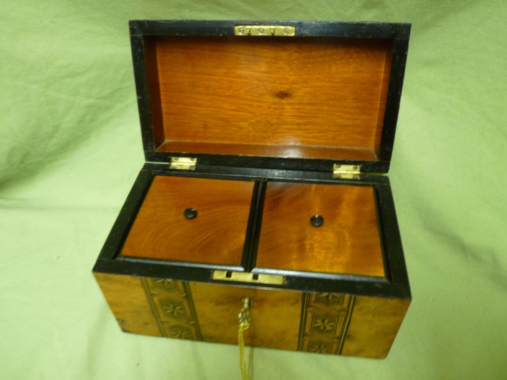 An open Victorian burr walnut tea caddy showcasing two interior lidded compartments and exterior geometric marquetry inlay. View XII