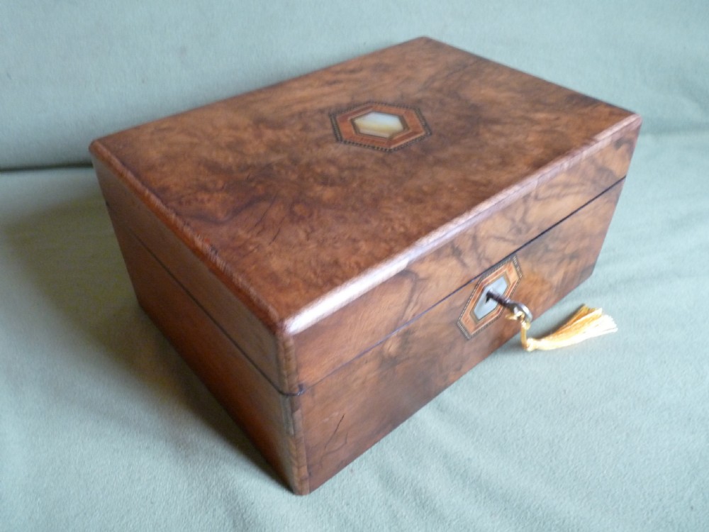 An open Victorian burr walnut jewellery box with a green silk lining, partitioned tray, and mother-of-pearl escutcheon. View II