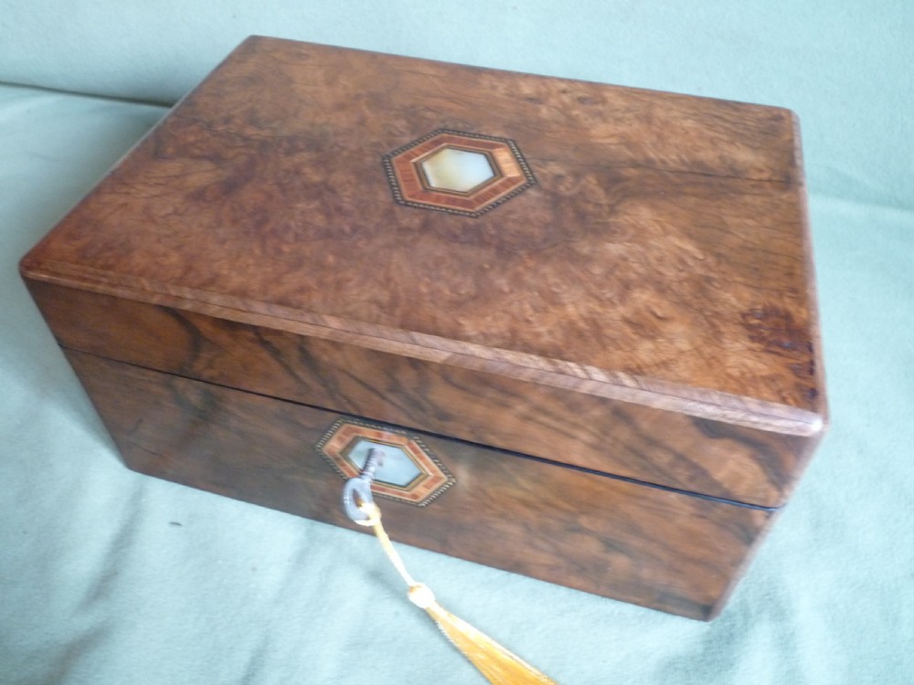 An open Victorian burr walnut jewellery box with a green silk lining, partitioned tray, and mother-of-pearl escutcheon. View III