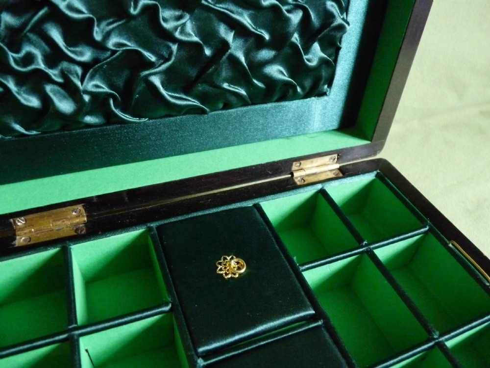 An open Victorian burr walnut jewellery box with a green silk lining, partitioned tray, and mother-of-pearl escutcheon. View V