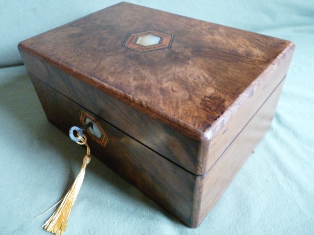 An open Victorian burr walnut jewellery box with a green silk lining, partitioned tray, and mother-of-pearl escutcheon. View IX