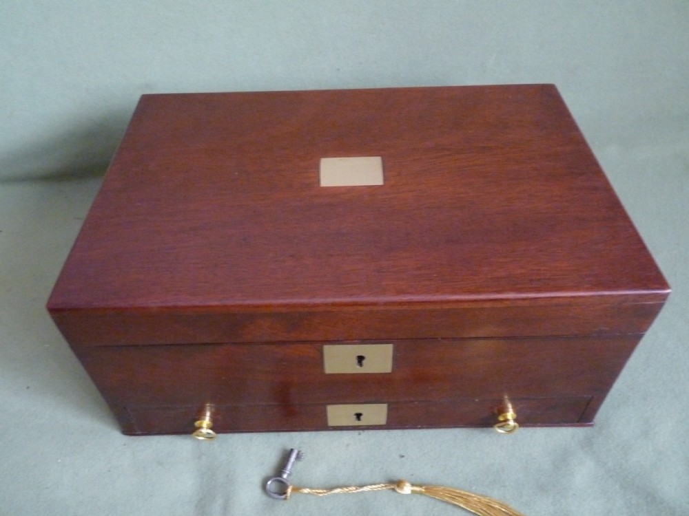 An open mahogany jewellery box featuring a pink-lined interior with tiered compartments, a lower drawer, and brass fittings. View IV