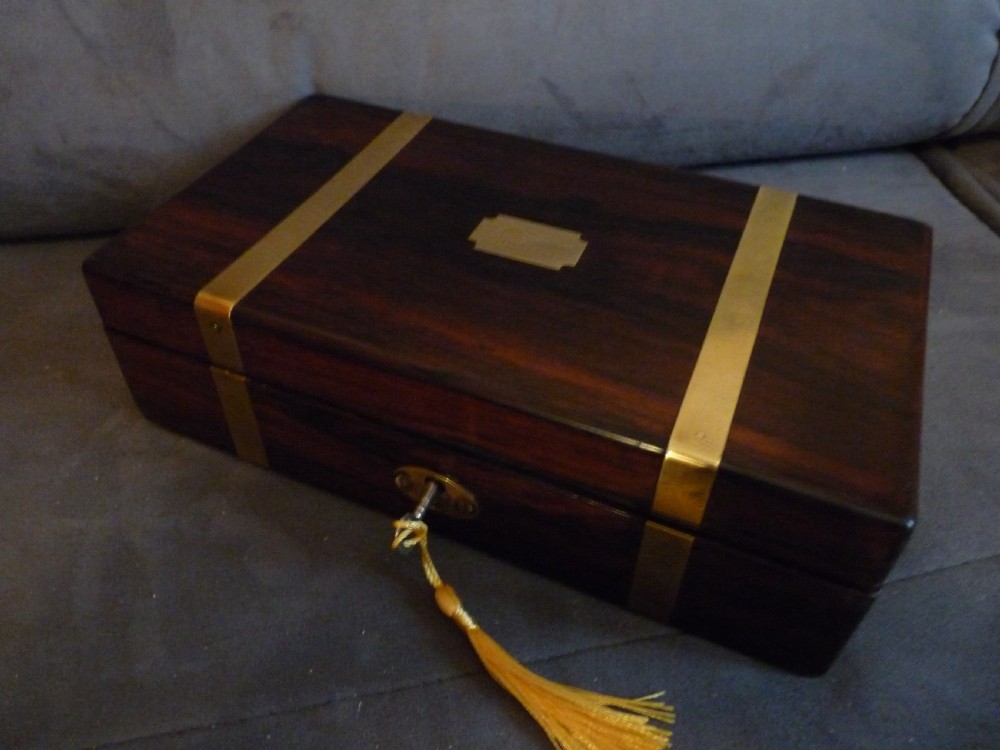 A dark rosewood rectangular box featuring polished brass straps across the lid and front with a central brass plaque and keyhole. View II