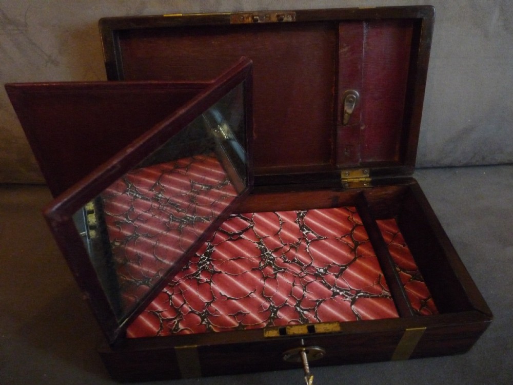 A dark rosewood rectangular box featuring polished brass straps across the lid and front with a central brass plaque and keyhole. View III