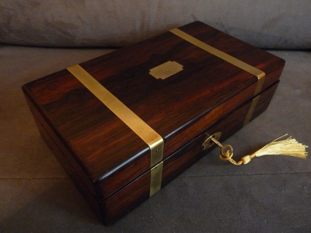 A dark rosewood rectangular box featuring polished brass straps across the lid and front with a central brass plaque and keyhole. View IV
