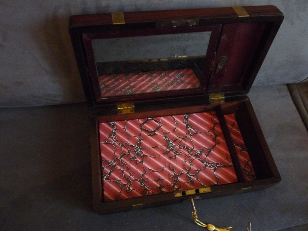A dark rosewood rectangular box featuring polished brass straps across the lid and front with a central brass plaque and keyhole. View VII
