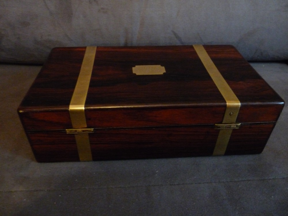 A dark rosewood rectangular box featuring polished brass straps across the lid and front with a central brass plaque and keyhole. View VIII
