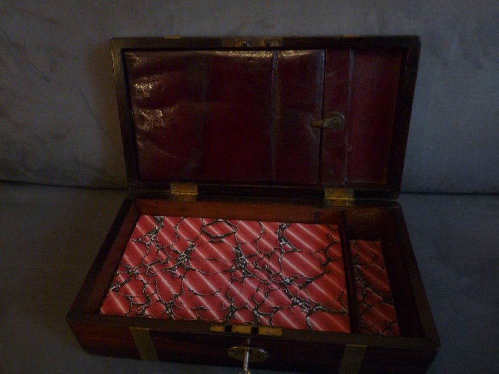 A dark rosewood rectangular box featuring polished brass straps across the lid and front with a central brass plaque and keyhole. View IX