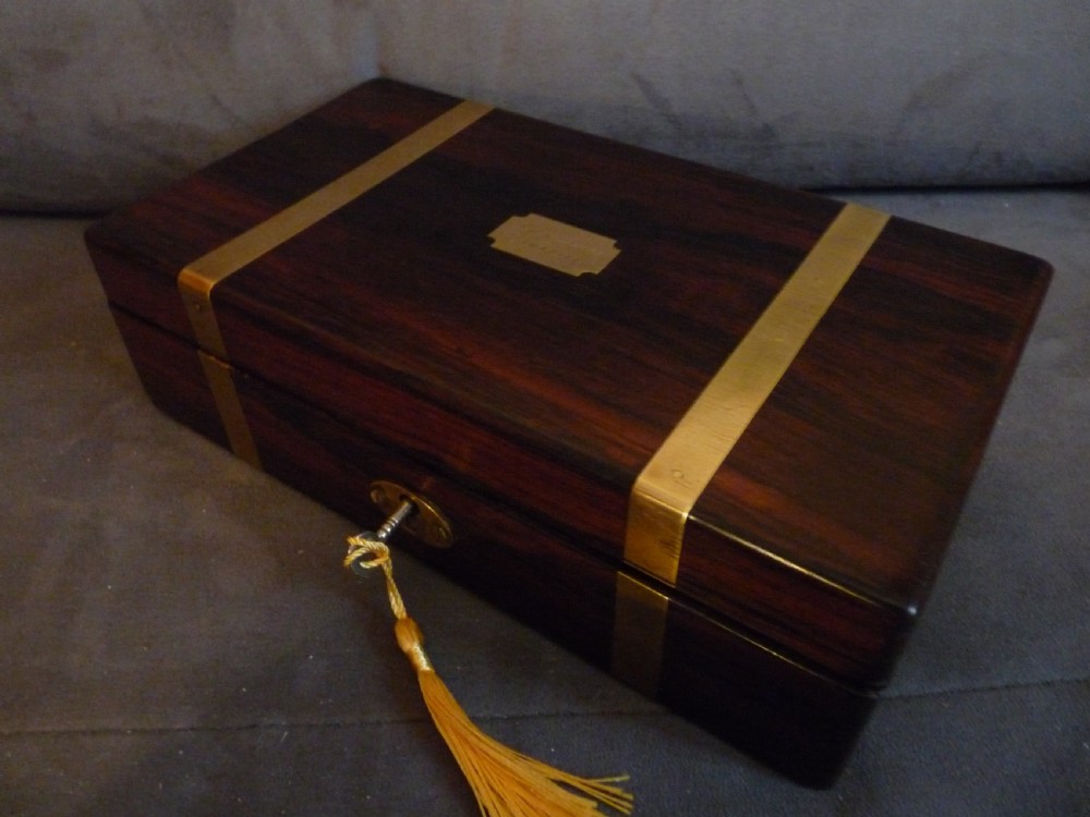 A dark rosewood rectangular box featuring polished brass straps across the lid and front with a central brass plaque and keyhole. View XII