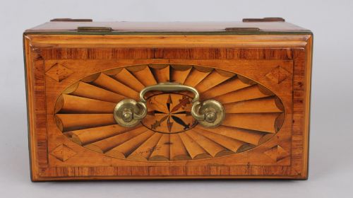 fig 1. A George III rectangular satinwood tea caddy featuring marquetry oval medallions, fan patterns, a brass top handle, and bracket feet.