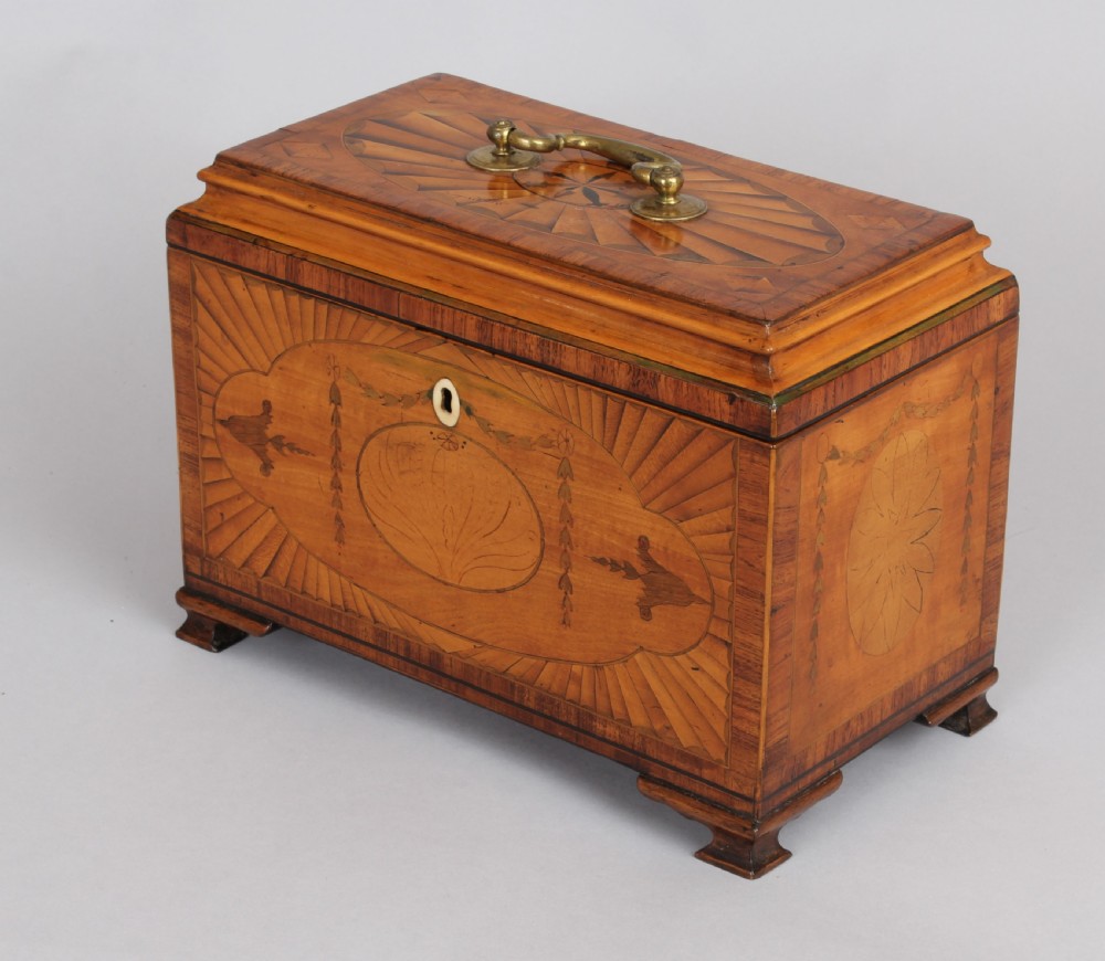 A George III rectangular satinwood tea caddy featuring marquetry oval medallions, fan patterns, a brass top handle, and bracket feet. View IV
