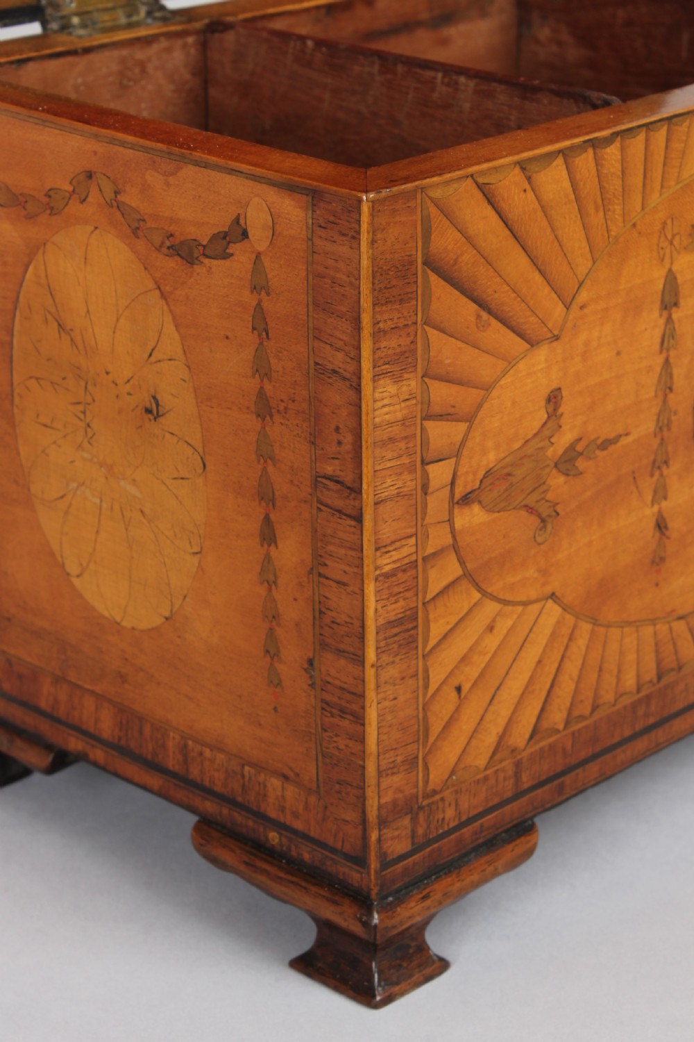 A George III rectangular satinwood tea caddy featuring marquetry oval medallions, fan patterns, a brass top handle, and bracket feet. View VI