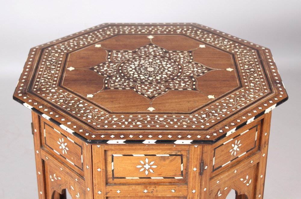 A nineteenth-century octagonal Anglo-Indian side table crafted from warm brown hardwood with elaborate floral star bone inlay and arched panel bases. View II