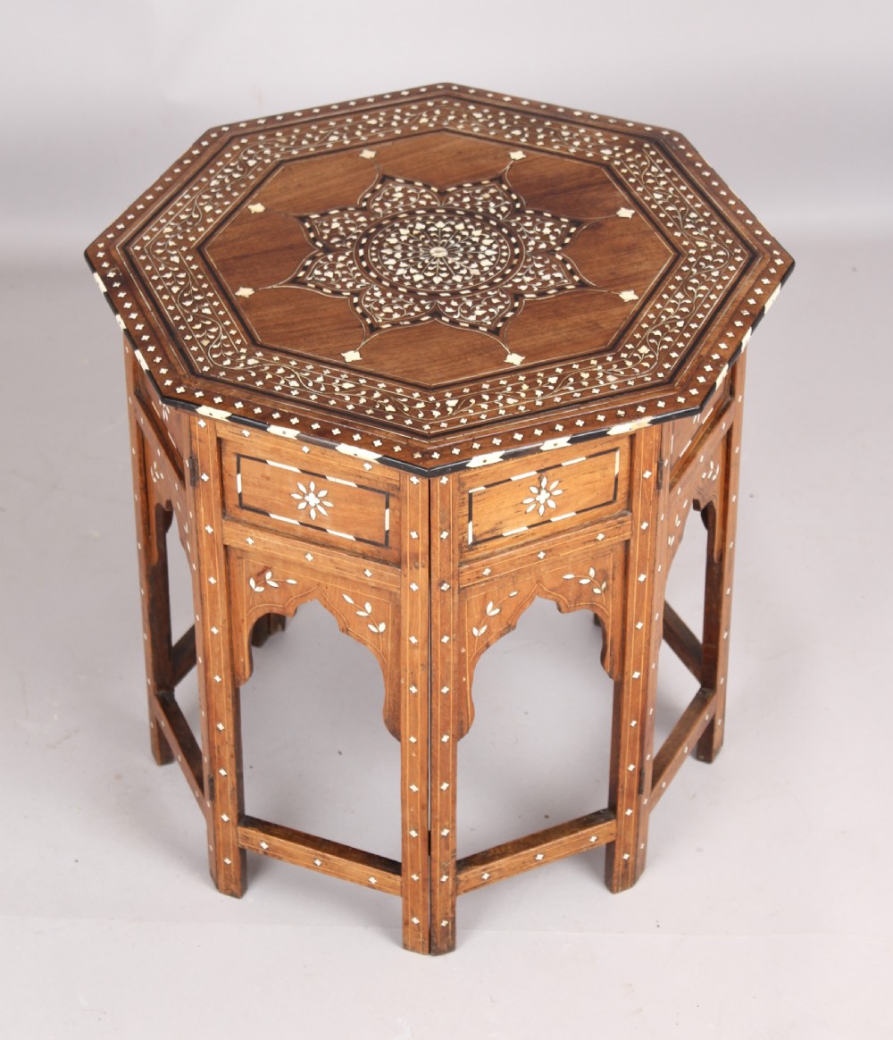 A nineteenth-century octagonal Anglo-Indian side table crafted from warm brown hardwood with elaborate floral star bone inlay and arched panel bases. View IV