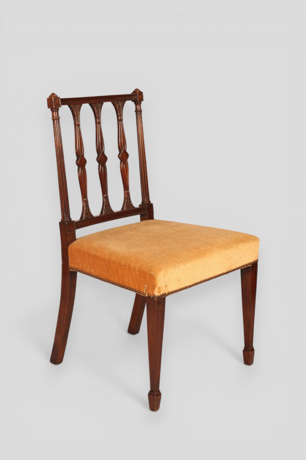 A set of eight mahogany dining chairs featuring carved spindle backs and mustard yellow velvet upholstered seats. View III
