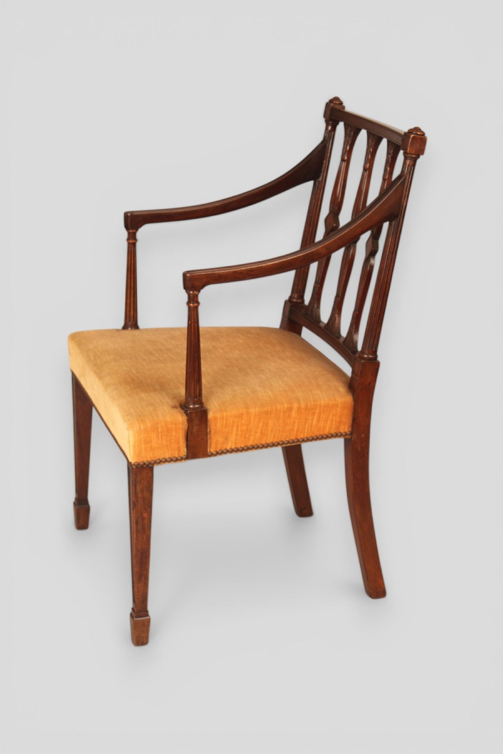 A set of eight mahogany dining chairs featuring carved spindle backs and mustard yellow velvet upholstered seats. View IV