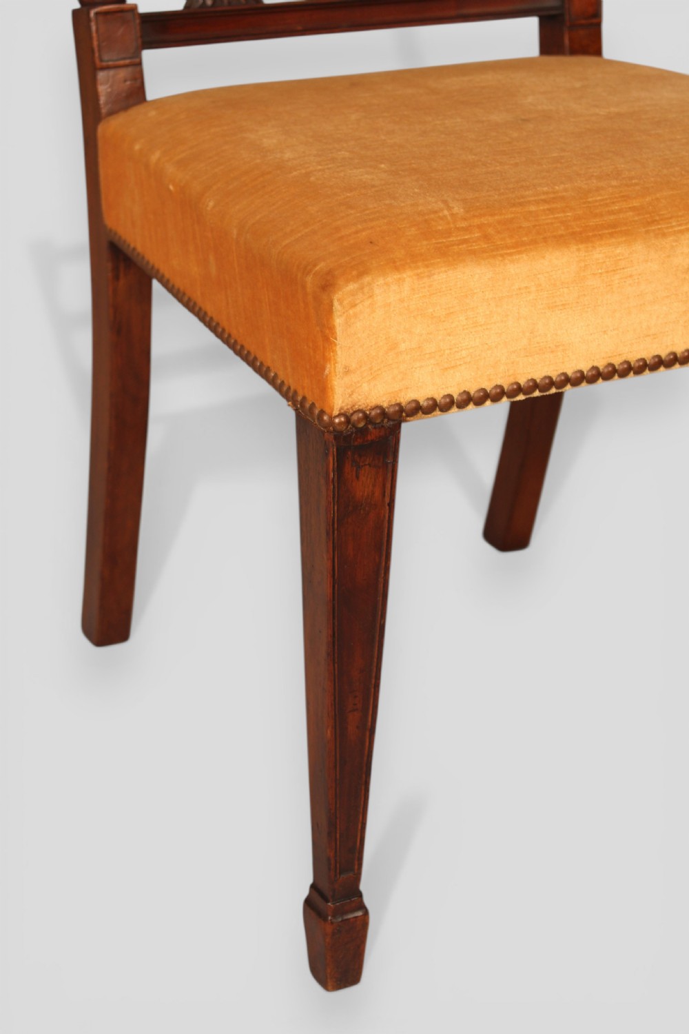 A set of eight mahogany dining chairs featuring carved spindle backs and mustard yellow velvet upholstered seats. View V