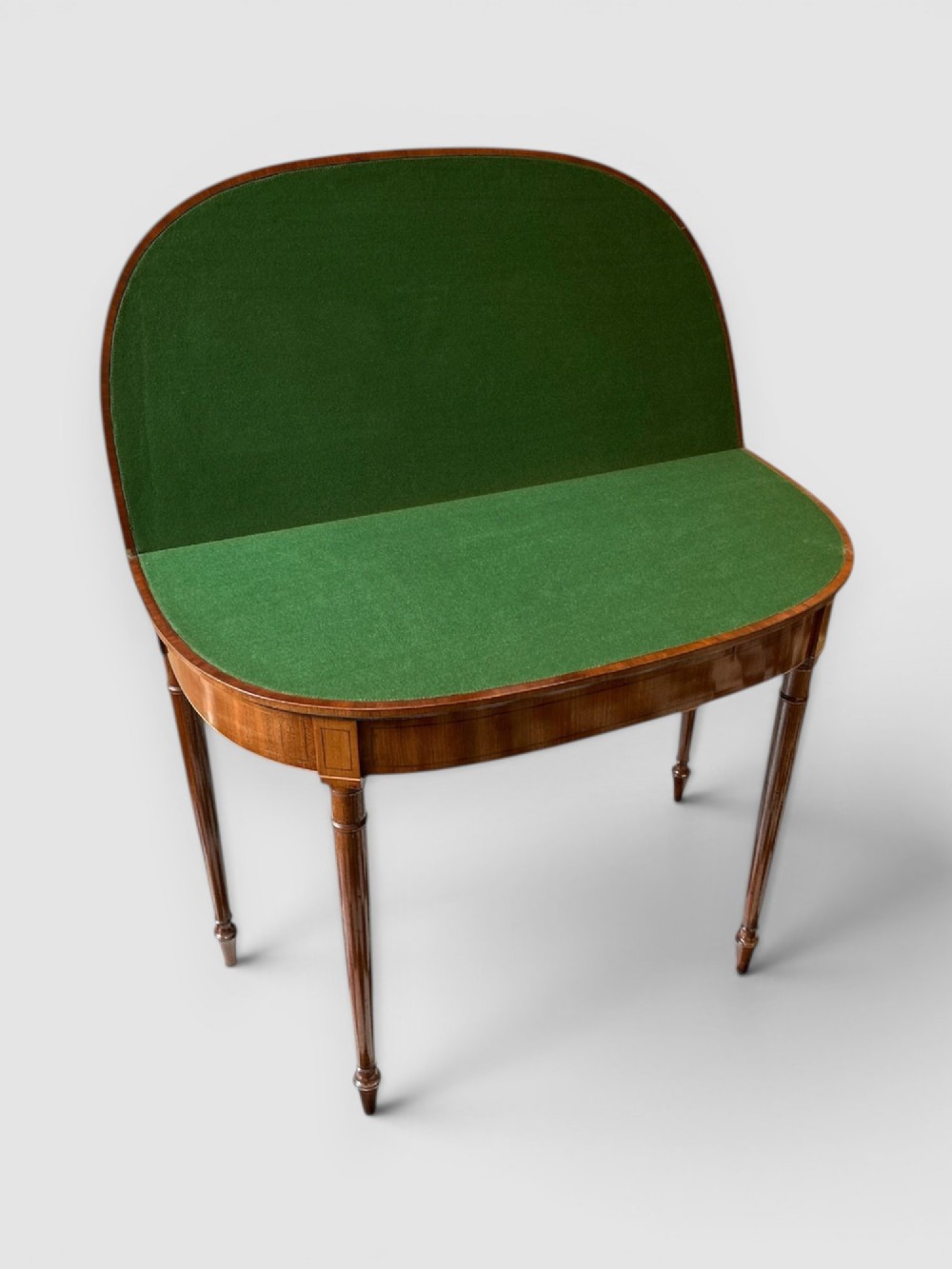 An early 19th-century mahogany demilune card table featuring satinwood crossbanding and turned tapered legs. View III