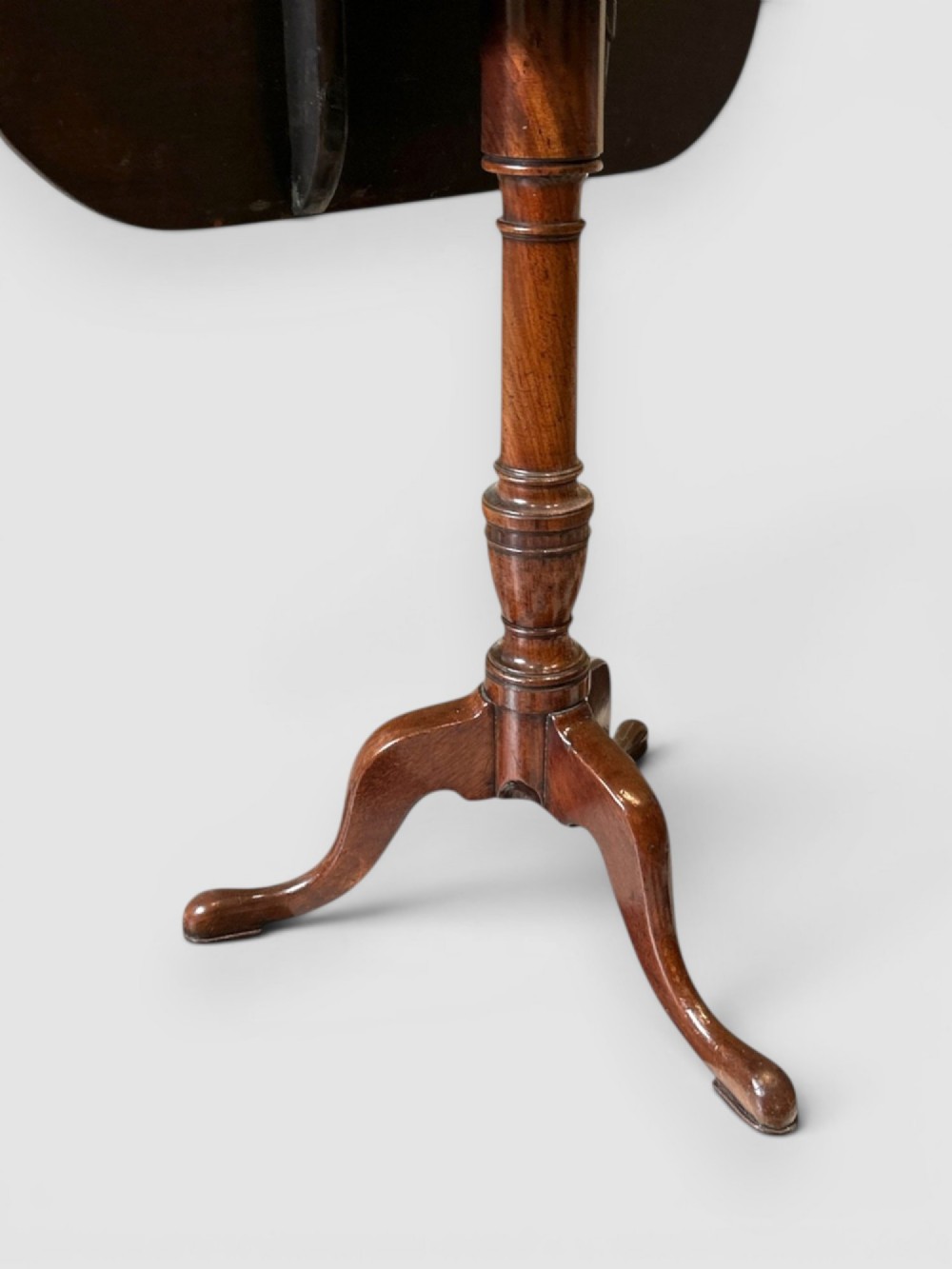 An antique dark mahogany tilt-top table featuring a rectangular surface with rounded corners supported by a turned central column and three curved legs. View III