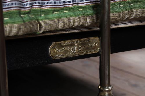 fig 3. An antique Victorian brass king-size bedstead featuring vertical tubular spindles, decorative cast connectors, top rail ball finials, and original white ceramic castors.