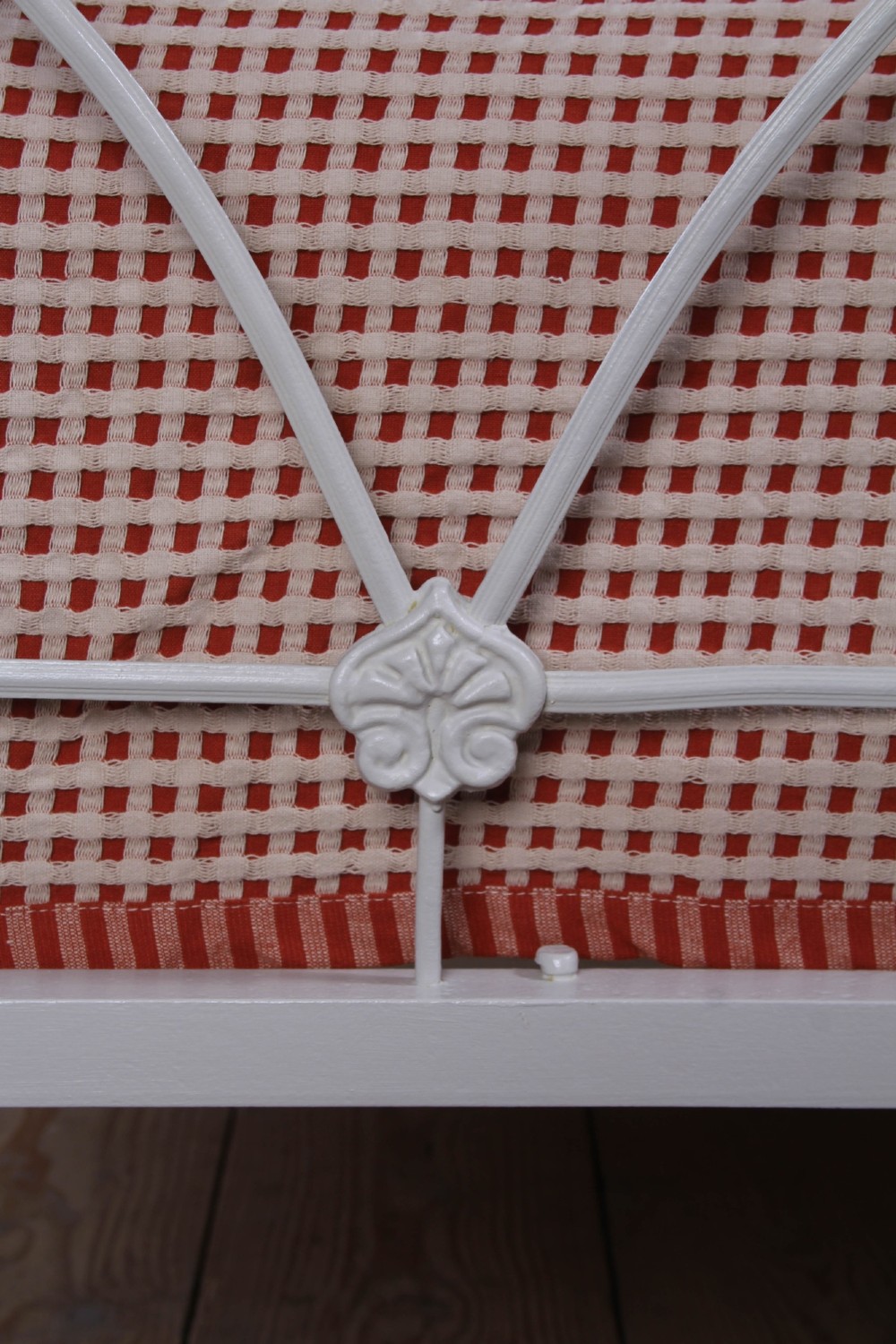 An off-white painted iron bedstead featuring a curved headboard and footboard with Celtic-style decorative metal scrollwork. View V