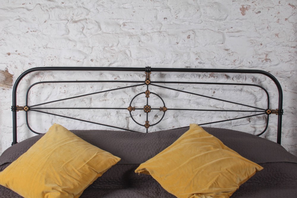 A Victorian super king black iron bed frame featuring geometric rod work and central brass highlights on the headboard. View II