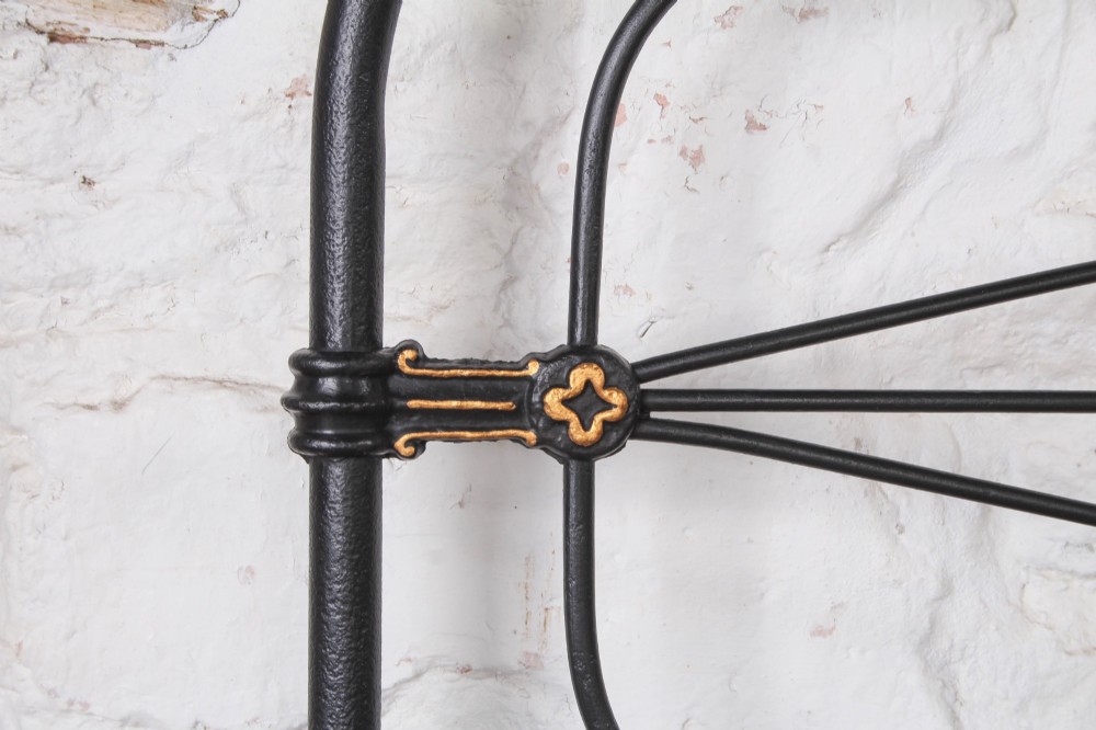 A Victorian super king black iron bed frame featuring geometric rod work and central brass highlights on the headboard. View IV