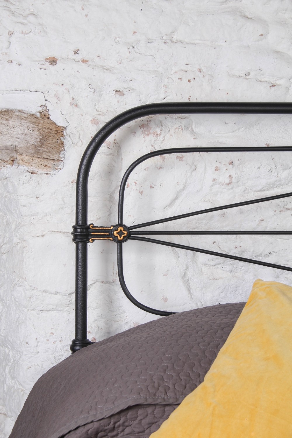 A Victorian super king black iron bed frame featuring geometric rod work and central brass highlights on the headboard. View VII
