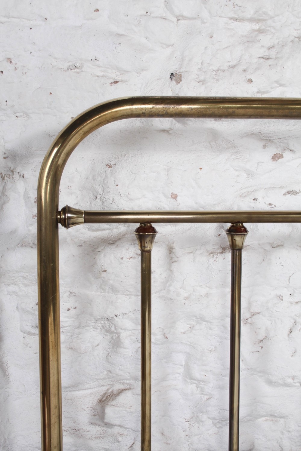 An antique French all-brass double bed frame featuring a rounded headboard and footboard with slender vertical spindles set on castor wheels. View VI