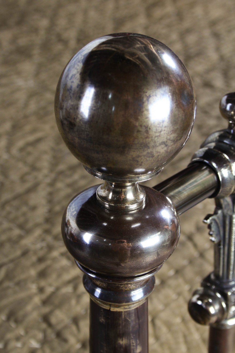 An antique Victorian brass king-size bedstead featuring vertical tubular spindles, decorative cast connectors, top rail ball finials, and original white ceramic castors. View VII