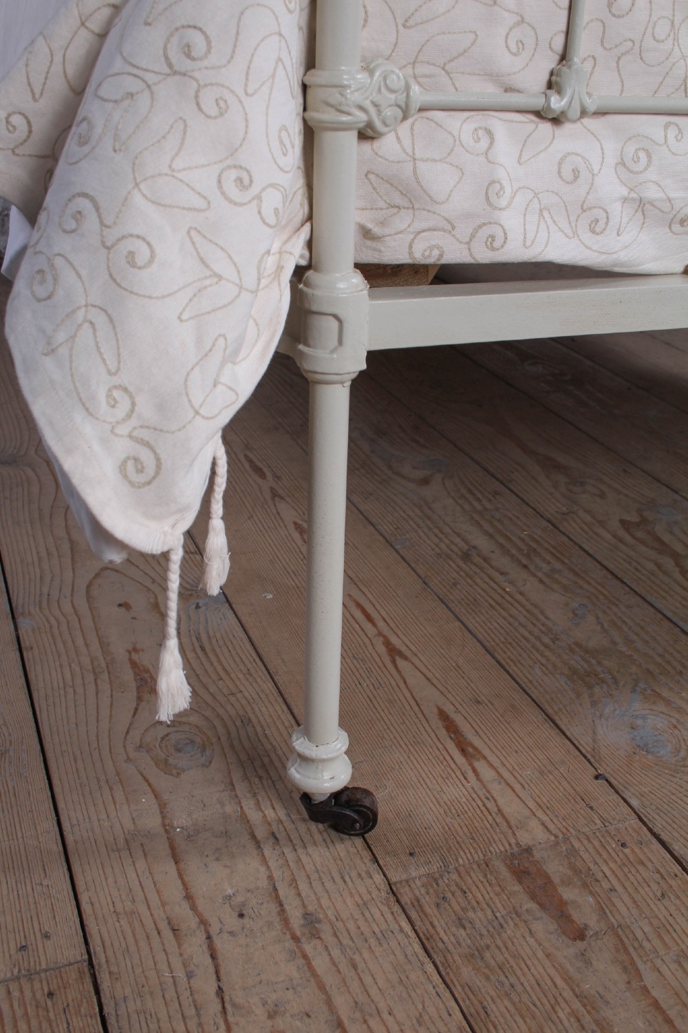 A Victorian cream-painted iron and brass three-quarter bedstead featuring vertical spindles, decorative cast motifs, and polished brass top rails with spherical finials. View IX