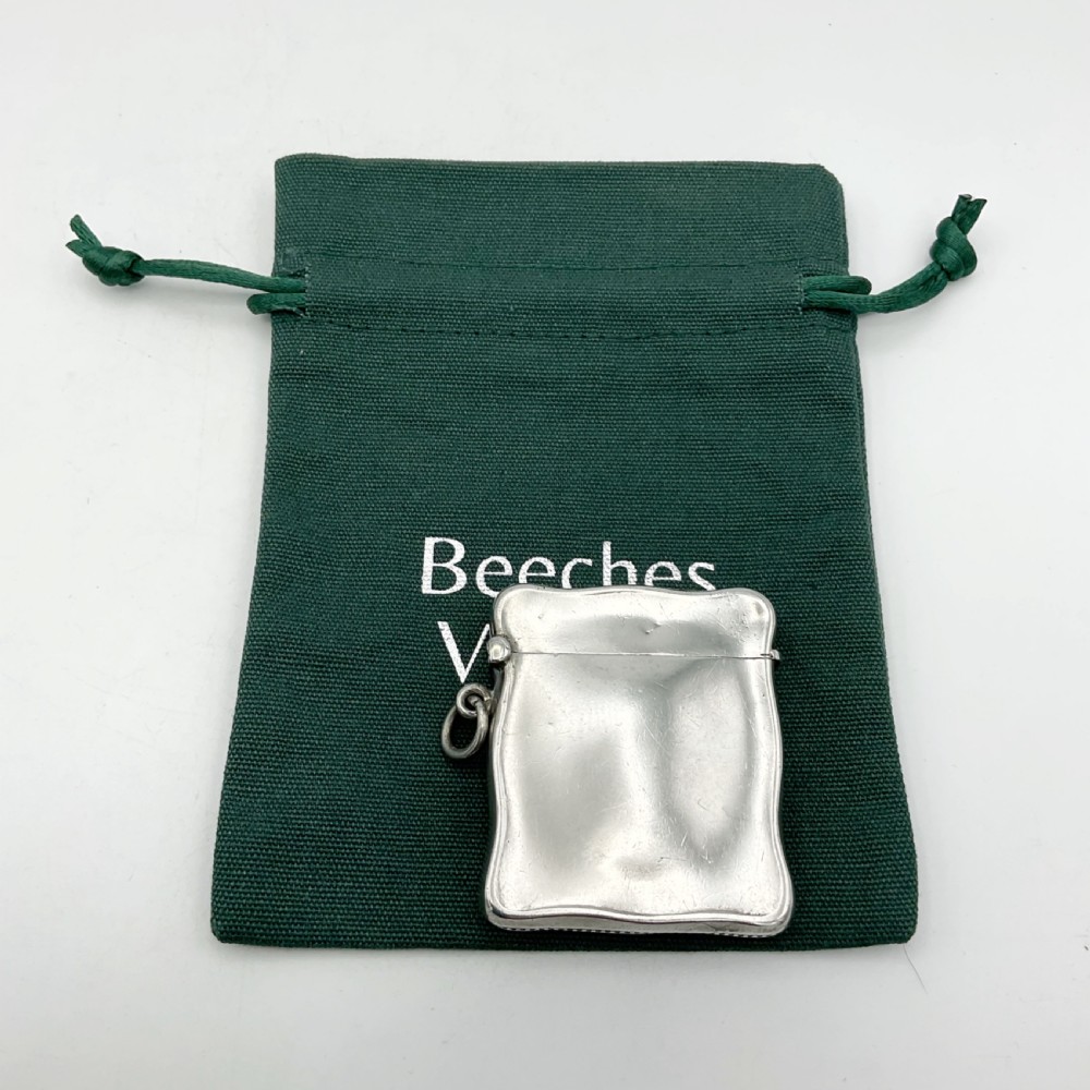 An Edwardian sterling silver vesta case with a contoured rectangular shape, side suspension ring, and hinged lid. View II