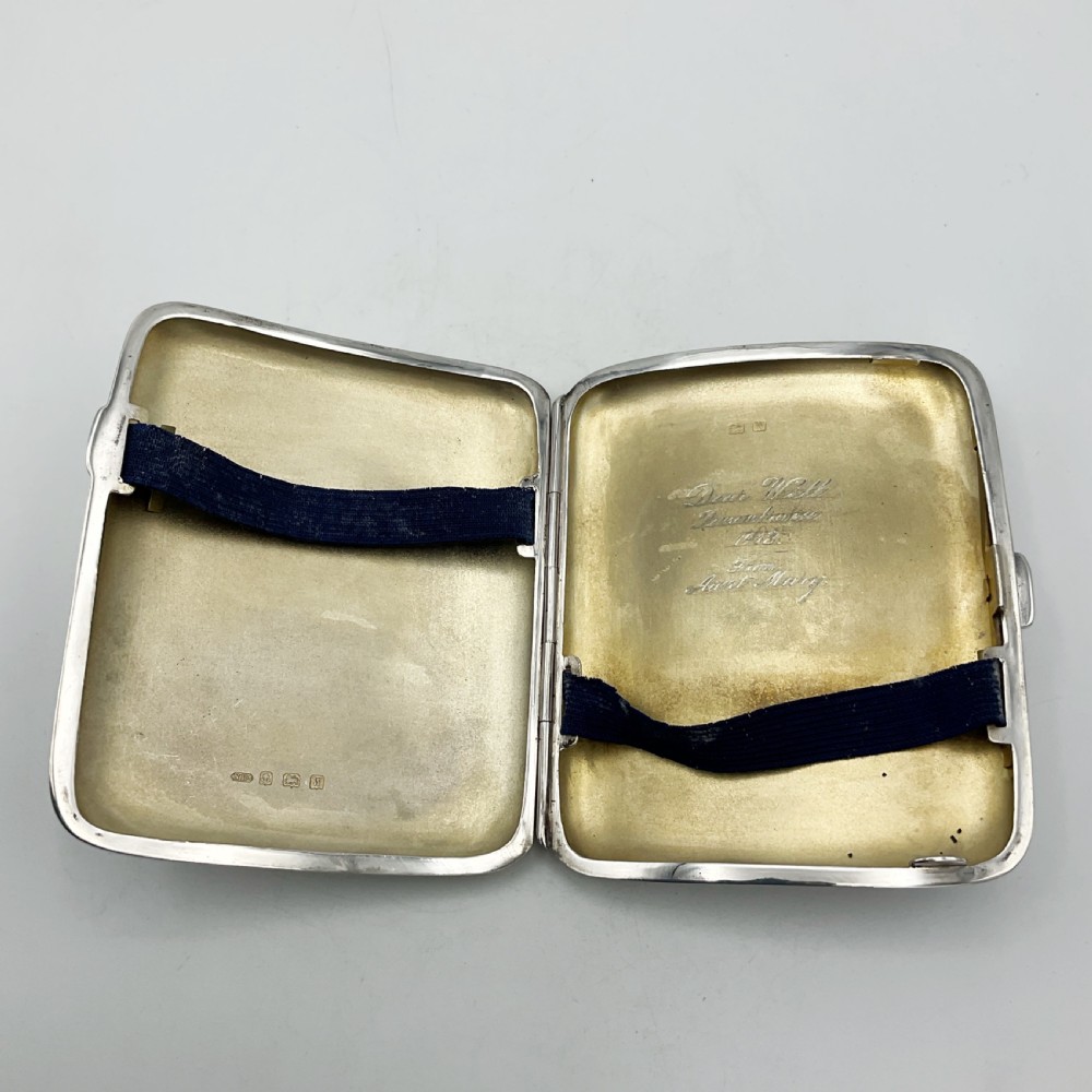 A curved rectangular sterling silver case featuring linear engine-turned pattern work and an engraved diamond monogram cartouche. View VIII